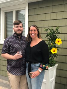 Man and Megan Landy next to flowers